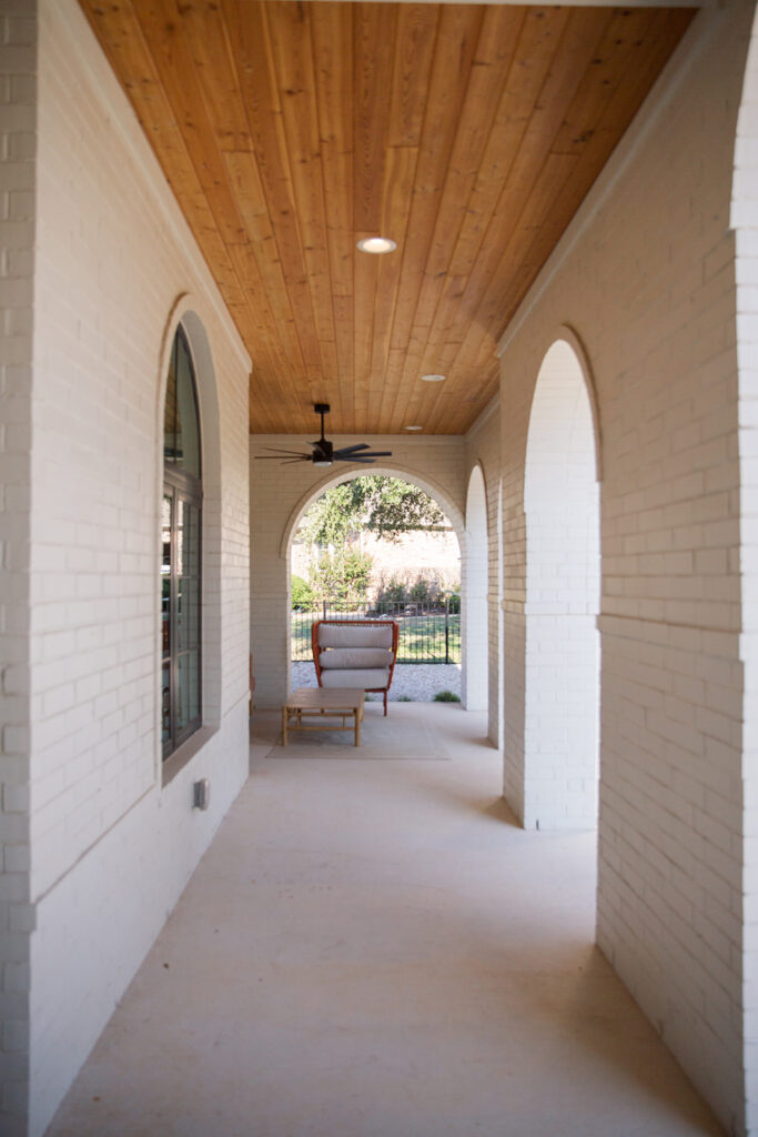 Five Oaks Custom Builders - Front Porch seating with white brick home exterior and arched porch pillars