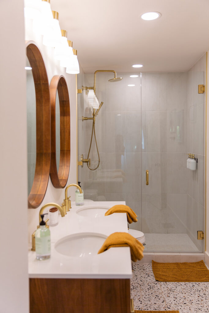 Five Oaks Custom Builders - luxury bathroom renovation, custom designed with subway and chevron tile in the shower. Updated minimalistic fixtures, gold brass metallic wood accessories in the bathroom. Austin, TX